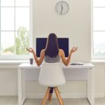 Person at Desk with Raised Arms